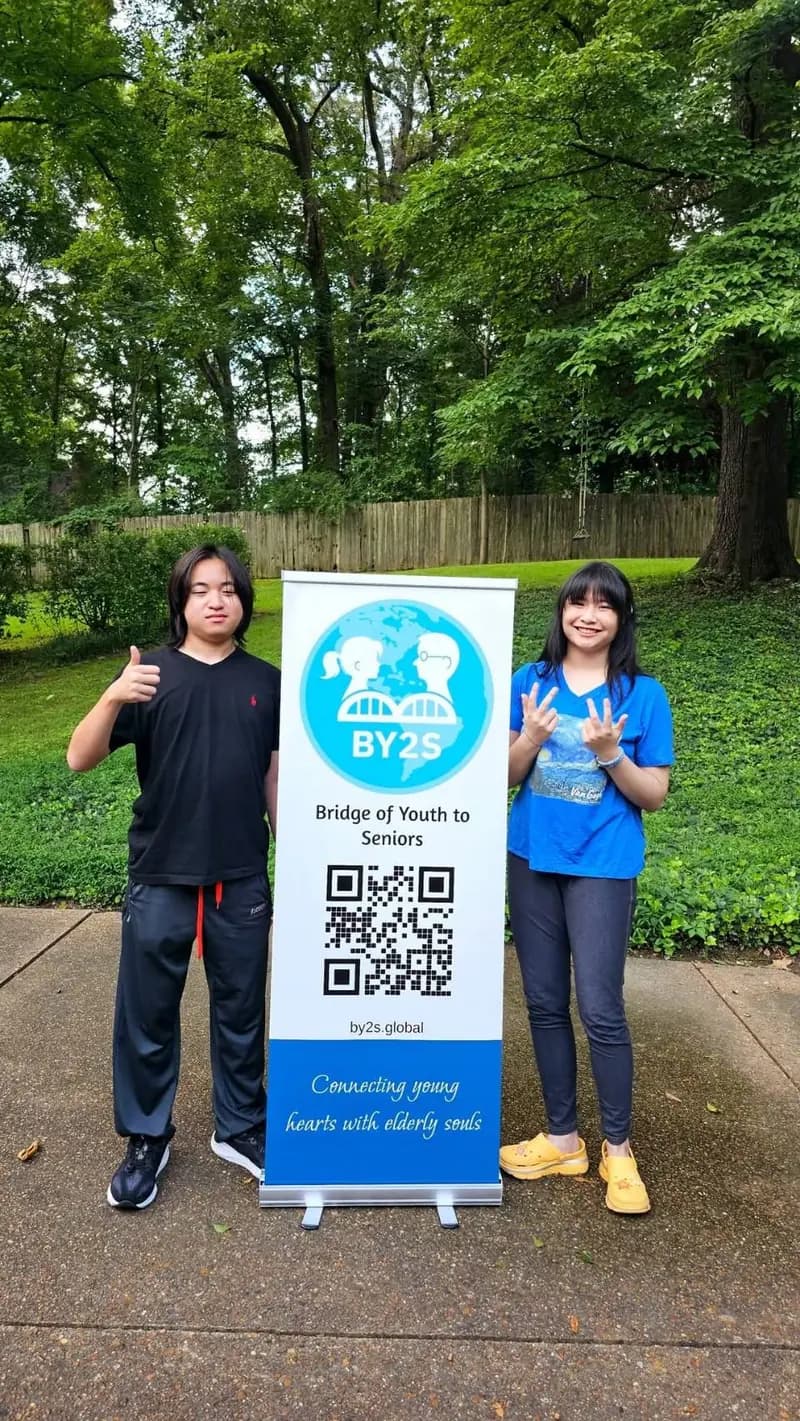 Noah and Acelynn standing beside the newly designed Bridge of Youth to Seniors banner they helped create.